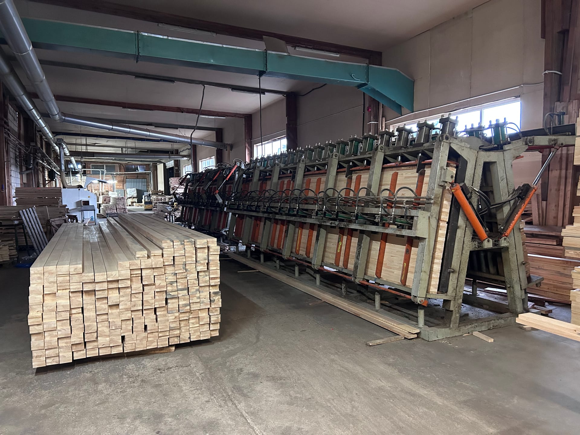 Prasa wielotłokowa do klejenia drewna w hali produkcyjnej